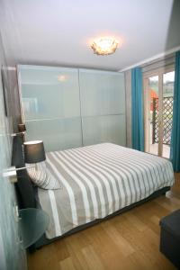 een slaapkamer met een bed met een gestreepte sprei bij Appartamento Deluxe Valadier in Spoleto