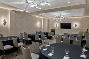 a conference room with tables and chairs and a screen at Delta Hotels by Marriott Ashland Downtown in Ashland