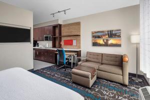 ein Hotelzimmer mit einem Bett und einem Sofa sowie einer Küche in der Unterkunft TownePlace Suites by Marriott Big Spring in Big Spring