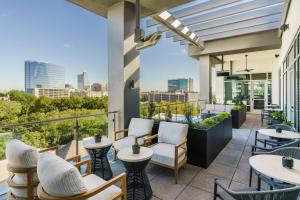 a patio with tables and chairs and a view of the city at AC Hotel By Marriott Raleigh Downtown in Raleigh