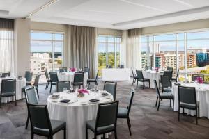 a banquet room with tables and chairs and windows at AC Hotel By Marriott Raleigh Downtown in Raleigh