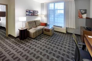 Habitación de hotel con sofá y silla en TownePlace Suites by Marriott Springfield, en Springfield
