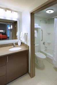 a bathroom with a sink and a toilet and a mirror at TownePlace Suites by Marriott Springfield in Springfield