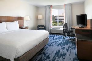 a hotel room with a bed and a desk and a television at Fairfield Inn & Suites by Marriott Tulsa Central in Tulsa