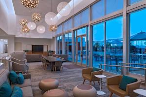 a lobby with a table and chairs and windows at Element Palmdale in Palmdale
