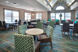 a waiting room with tables and chairs and windows at Residence Inn Cranbury South Brunswick in Cranbury