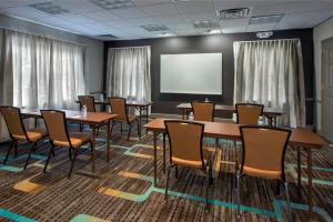a conference room with tables and chairs and a screen at Residence Inn Cranbury South Brunswick in Cranbury