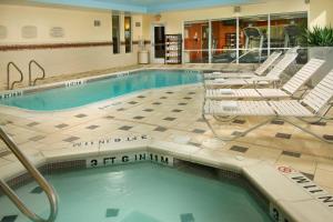 Fairfield Inn & Suites by Marriott New Braunfels في نيو بروانفيلز: مسبح الفندق والكراسي والمسبح