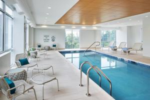a swimming pool with chairs and tables and chairs around it at Element Valley Forge King of Prussia in King of Prussia