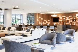 a lobby with white furniture and a bar at AC Hotel By Marriott Dallas By The Galleria in Dallas