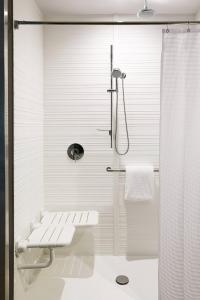 a white bathroom with a shower and a toilet at AC Hotel By Marriott Dallas By The Galleria in Dallas