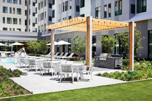 a patio with tables and chairs next to a building at AC Hotel By Marriott Dallas By The Galleria in Dallas