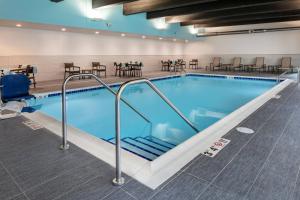a large swimming pool with chairs and tables in a building at Courtyard Sioux City Downtown/Convention Center in Sioux City