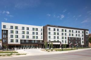 a large white hotel building on a street at Courtyard Sioux City Downtown/Convention Center in Sioux City