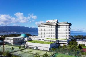 un hôtel avec un grand bâtiment en face de l'eau dans l'établissement Lake Biwa Marriott Hotel, à Moriyama