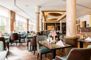 a restaurant with tables and chairs and a bar at Dorint Venusberg Bonn in Bonn