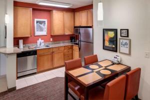 a kitchen with a wooden table and a dining room at Residence Inn Jackson Ridgeland in Ridgeland