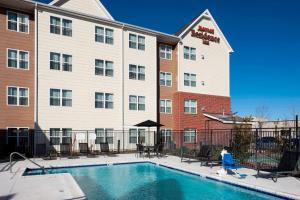a person walking by a pool in front of a hotel at Residence Inn Jackson Ridgeland in Ridgeland