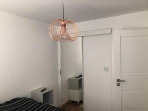 a room with a bed and a hanging light at Apartament u Lali in Ustka