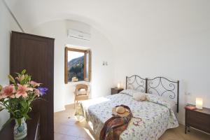 a bedroom with a bed and a vase of flowers at La Scivitella in Amalfi