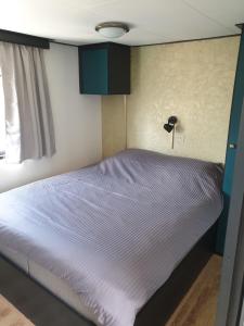 uma cama num pequeno quarto com uma cama azul em Vintage chalet Fereale II em Grou