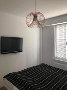 a bedroom with a bed and a flat screen tv at Apartament u Lali in Ustka