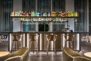 a bar in a restaurant with bar stools at AC Hotel Torino by Marriott in Turin