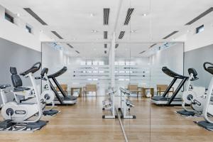 un gimnasio con cintas de correr y máquinas elípticas en AC Hotel Torino by Marriott en Turín