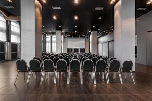 una fila de sillas en una habitación con pantalla en AC Hotel Torino by Marriott en Turín