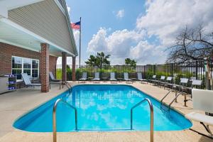 a swimming pool with chairs at Residence Inn by Marriott Austin The Domain Area in Austin