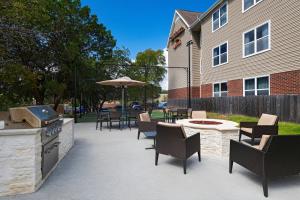 a patio with a grill and chairs and a table with an umbrella at Residence Inn by Marriott Austin The Domain Area in Austin
