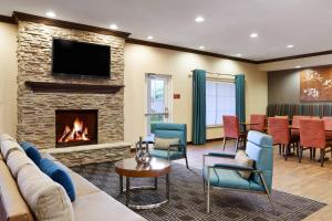 a living room with a fireplace and a couch and chairs at TownePlace Suites by Marriott Midland in Midland