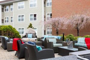 un grupo de sillas y mesas frente a un edificio en Residence Inn by Marriott Portsmouth en Portsmouth