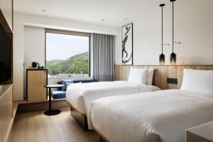 a hotel room with two beds and a window at Fairfield by Marriott Hyogo Awaji Fukura in Minamiawaji