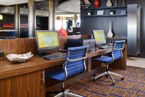 an office with two computers on a desk with two chairs at Courtyard by Marriott Galveston Island in Galveston