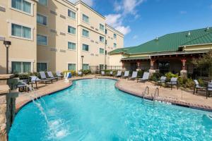 een zwembad tegenover een hotel met stoelen en een gebouw bij Courtyard by Marriott Abilene Northeast in Abilene