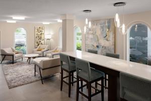 Fairfield Inn and Suites by Marriott Palm Beach في بالم بيتش: غرفة معيشة مع بار وكراسي