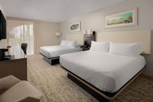 Fairfield Inn and Suites by Marriott Palm Beach في بالم بيتش: غرفة فندقية بسريرين واريكة