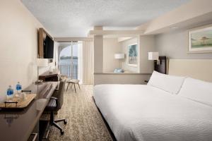 Fairfield Inn and Suites by Marriott Palm Beach في بالم بيتش: غرفة الفندق بسرير ابيض ومكتب ومكتب