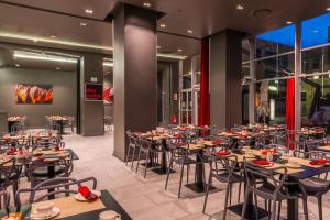 a restaurant with tables and chairs in a building at Protea Hotel by Marriott Gaborone Masa Square in Gaborone