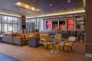 a hotel lobby with couches and tables and a bar at Houston Marriott West Loop by The Galleria in Houston