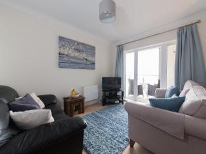 a living room with two couches and a television at Lower Chine Apartment in Shanklin