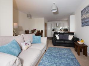a living room with a white couch and a blue rug at Lower Chine Apartment in Shanklin