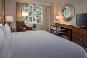 a hotel room with a large bed and a television at Marriott Marquis Washington, DC in Washington, D.C.