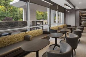 um restaurante com mesas, cadeiras e janelas em SpringHill Suites by Marriott Tuckahoe Westchester County em Tuckahoe