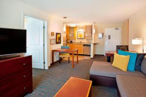 a living room with a couch and a flat screen tv at Residence Inn by Marriott Portland Airport at Cascade Station in Portland