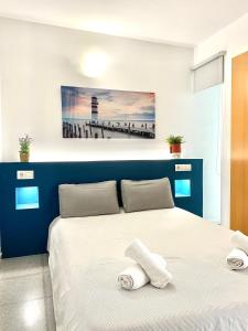 a bedroom with a blue and white bed with towels on it at Acogedor Apartamento in Valencia