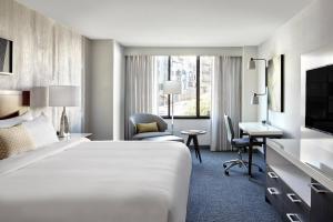 Una habitación de hotel con una cama grande y un escritorio. en San Francisco Marriott Fisherman's Wharf, en San Francisco