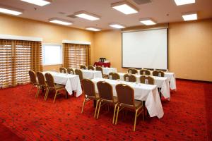 a conference room with tables and chairs and a screen at Residence Inn La Mirada Buena Park in La Mirada