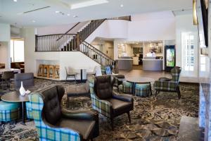 a lobby with chairs and tables and a staircase at Residence Inn La Mirada Buena Park in La Mirada